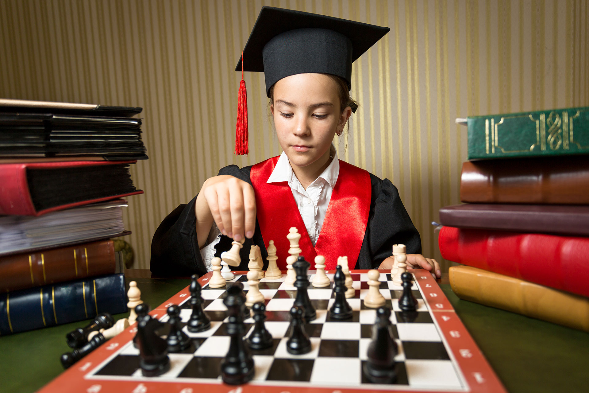 portrait-of-smart-girl-in-graduation-cap-playing-c-MVQC78K.jpg